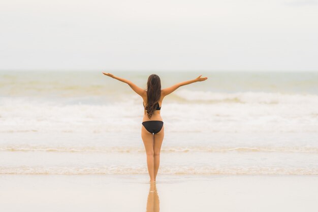 De slijtagebikini van de portret mooie jonge Aziatische vrouw op de strand overzeese oceaan