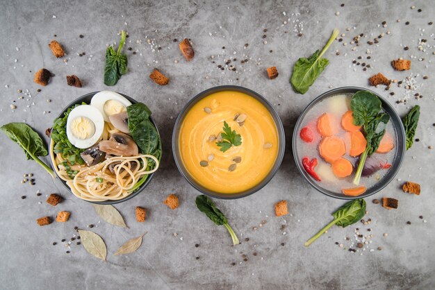 De soepen en de ingrediënten op vlakke keukentafel lagen