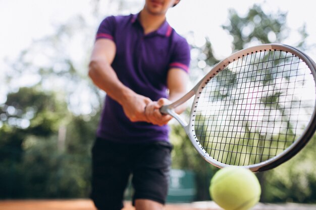 De speler van het jonge mensentennis bij het hof, dichte omhooggaand van de tennisracket