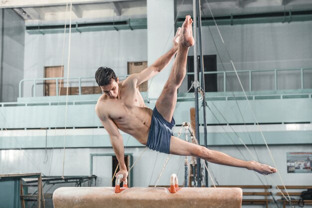 De sportman tijdens moeilijke oefeningen, sportgymnastiek