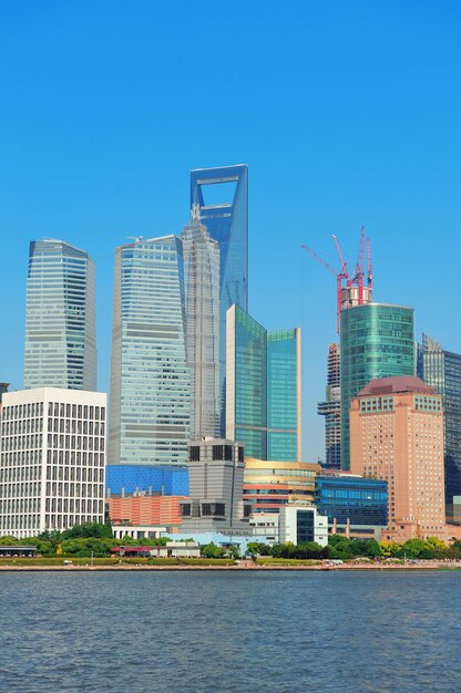 De stedelijke skyline van Shanghai met blauwe heldere hemel over de Huangpu-rivier.