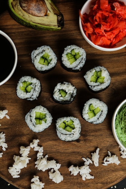 Gratis foto de sushibroodjes dienden op houten plaat met klassieke ingrediënten hoogste mening