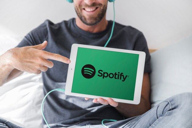 De tablet van de jonge mensenholding met spotify app