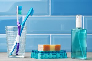 Gratis foto de tandenborstels in een glas in blauwe badkamer