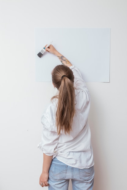 Gratis foto de tekeningsbeeld van de kunstenaar op papier op muur