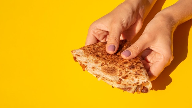 De tortilla van de de vrouwenholding van de close-up met gele achtergrond