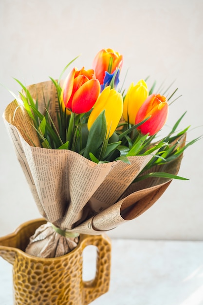 Gratis foto de tulp bloeit boeket in pakpapier in kruik