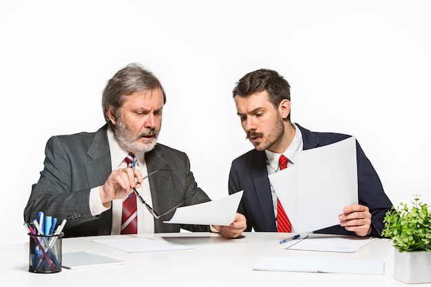 De twee collega's werken samen op kantoor.