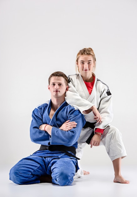 De twee judoka's strijders poseren op grijs