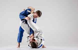 Gratis foto de twee judokastrijders vechten tegen mannen