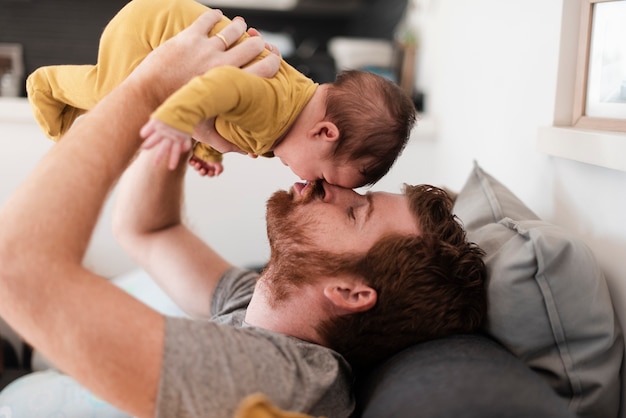 De vaderzitting van de close-up op de laag met baby