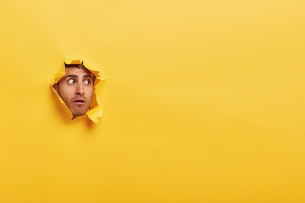 De verbaasde ongeschoren man heeft een bedwelmde uitdrukking