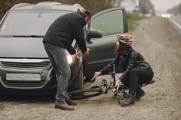 De vrouw botste tegen de auto. Meisje in een helm.