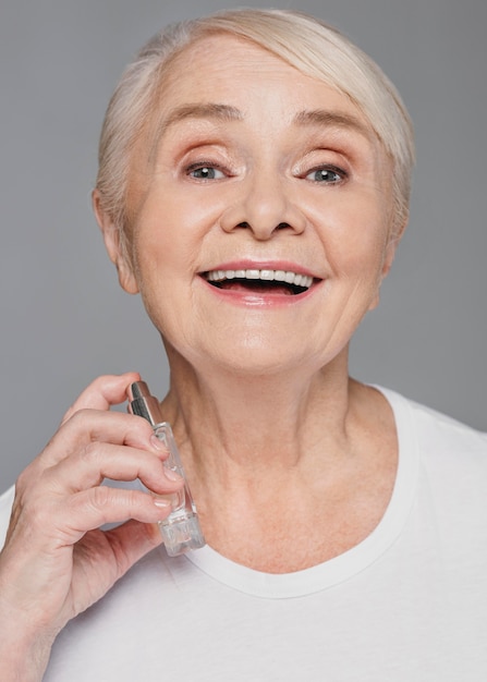 De vrouw die van de close-upsmiley parfum gebruikt