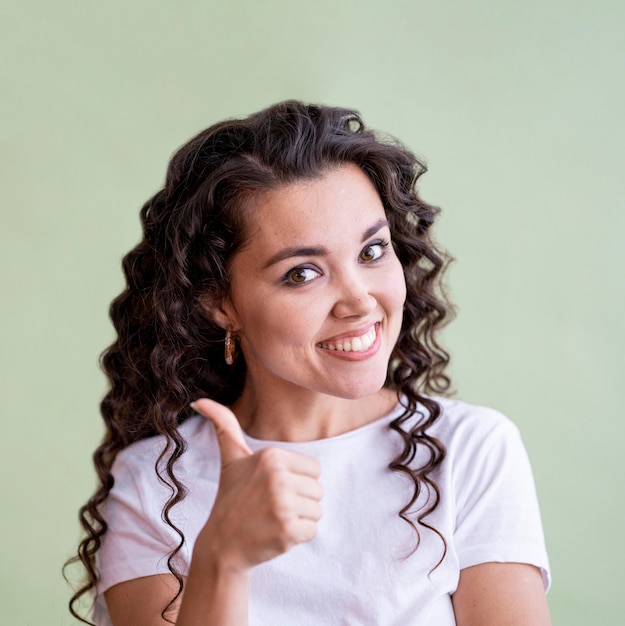 Gratis foto de vrouw die van smiley de duimen omhoog doet