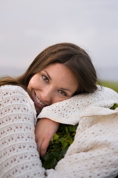 Gratis foto de vrouw die van zijaanzichtsmiley buiten stellen