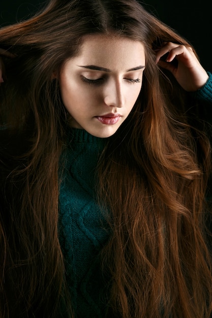 De vrouw houdt haar indient lang bruin haar