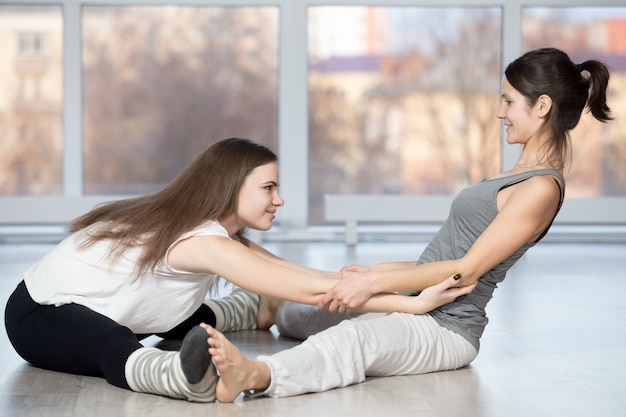 De vrouw te helpen een andere stretch terug