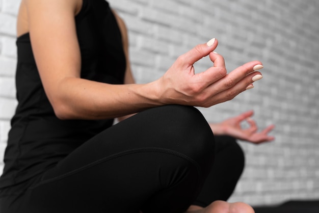 De vrouw van de close-up in yoga stelt