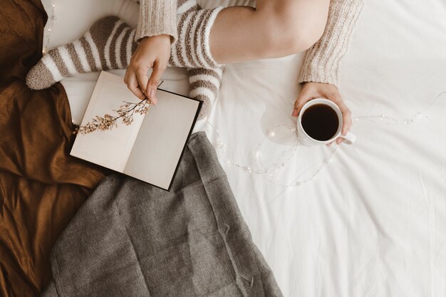 De vrouw van het gewas met drank die bloem op boek zet