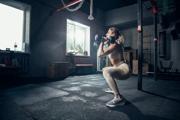 De vrouwelijke atleet traint hard in de sportschool. fitness en gezond leven concept.