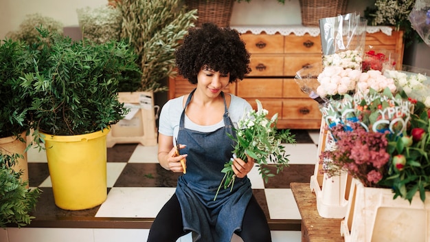 De vrouwelijke bos van de bloemistholding van bloemen in winkel