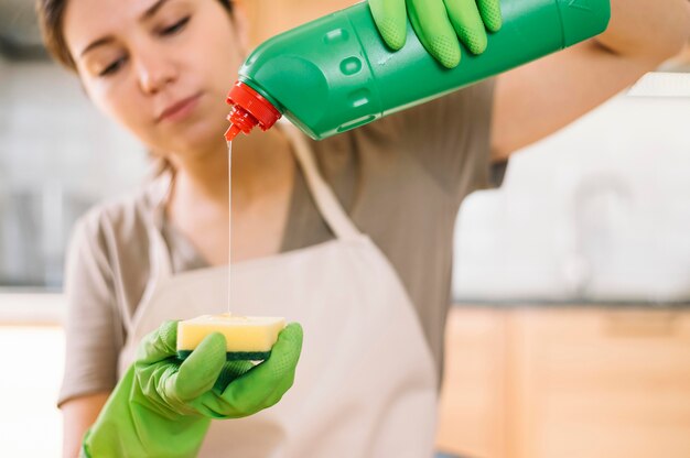 De vrouwen gietende schoonmakende oplossing van de close-up