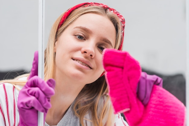 Gratis foto de vrouwen schoonmakende vensters van de close-up