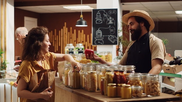 Gratis foto de winkelier van de supermarkt helpt de klant