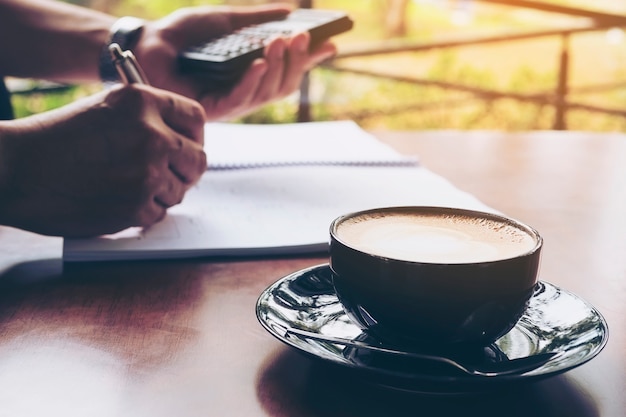 De zakenman werkt met zijn computer in koffiewinkel