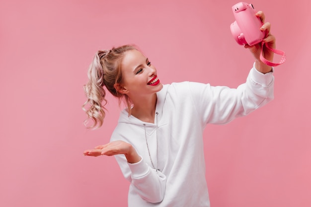 Debonair vrouw met krullend kapsel selfie maken