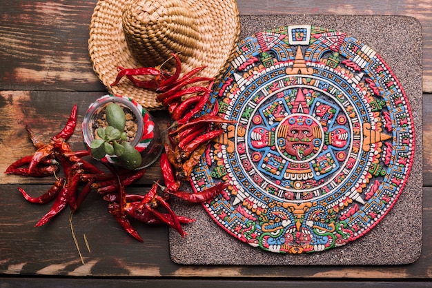 Decoratief Mexicaans symbool aan boord van dichtbij droge Spaanse peper en sombrero