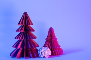 Decoratief papier kerstbomen op blauwe achtergrond met trendy neonlicht