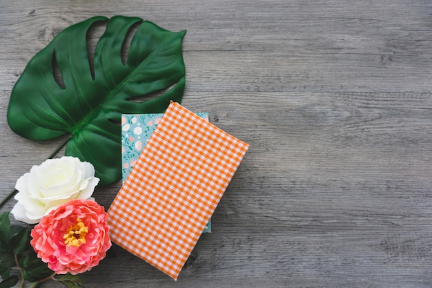 Gratis foto decoratieve achtergrond met bloemen, boeken en palmblad