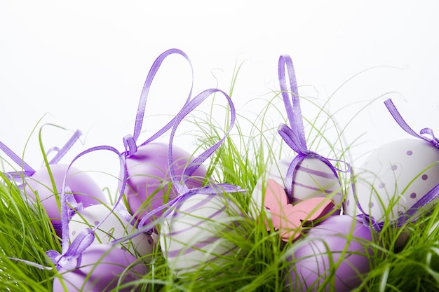 Decoratieve Pasen eieren met paars lint op het gras