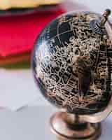 Gratis foto decoratieve zwarte en bronzen globe op het bureau