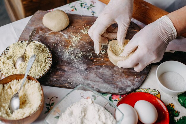 deeg vlees maaltijd gebak tijdens het maken van deeg koken meel eieren op bruin hout rustiek bureau