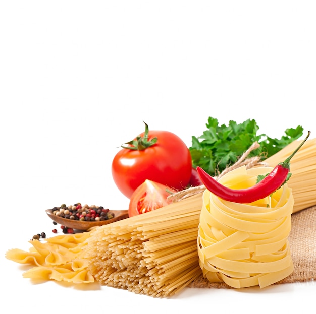 Deegwarenspaghetti, groenten, kruiden die op wit worden geïsoleerd