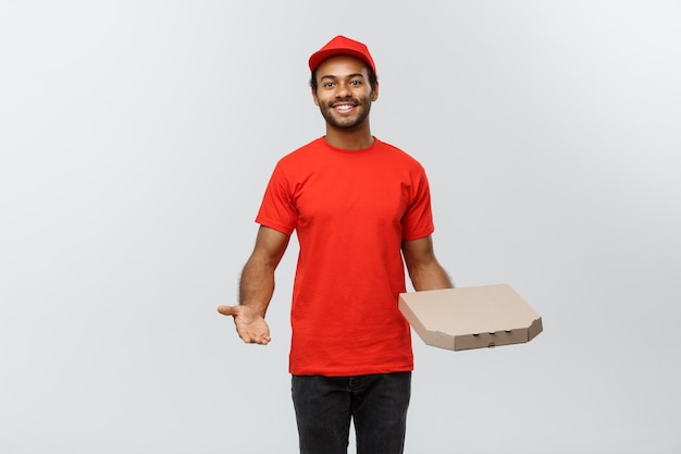 Delivery Concept - Portret van knappe Afro-Amerikaanse Pizza Delivery Man. Geïsoleerd op grijze studio achtergrond. Ruimte kopiëren.