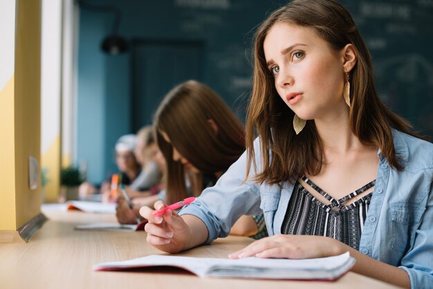 Denkende schoolmeisje kijken naar camera