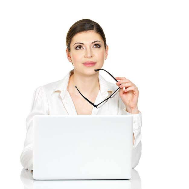 Denkende vrouw met laptop in wit overhemd - dat op wit wordt geïsoleerd.