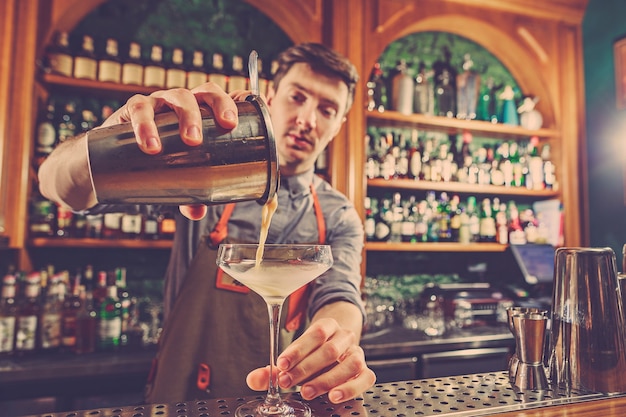 Deskundige barman maakt cocktail in nachtclub.