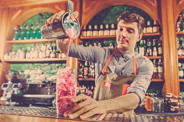 Deskundige barman maakt cocktail in nachtclub.