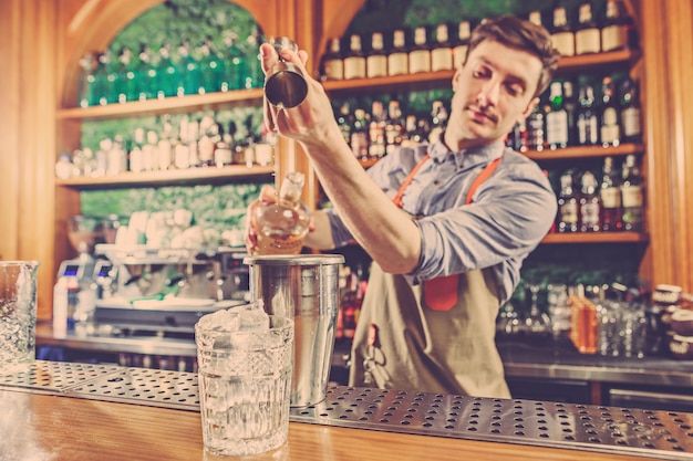 Deskundige barman maakt cocktail in nachtclub.