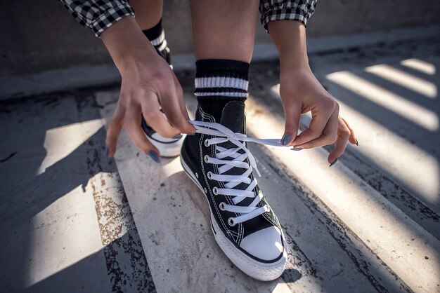 Details van vrouwenschoen die haar klassieke sneakers snijdt