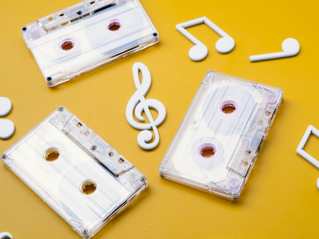 Gratis foto diagonale weergave witte cassettebandjes met muzieknoten rond