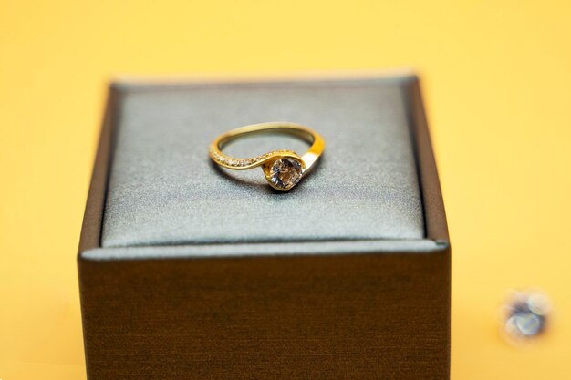 Diamanten ring in sieraden geschenkdoos op gele achtergrond