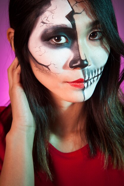 Dichte omhooggaand oog van vrouw die halloween masker draagt