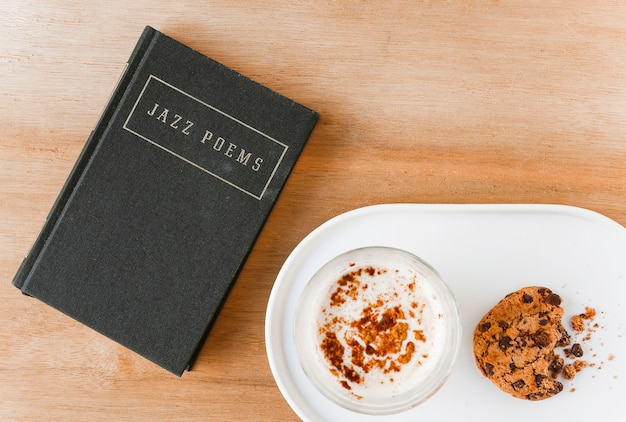 Dichtersboek met koffie en gegeten koekjes op plaat