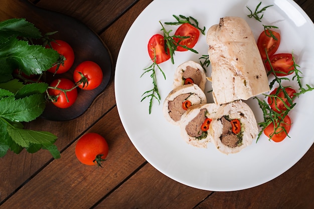 Dieet gebakken kiprolletjes gevulde lever, chili en kruiden met een salade van tomaten en rucola. Dieetmenu. Goede voeding. Bovenaanzicht